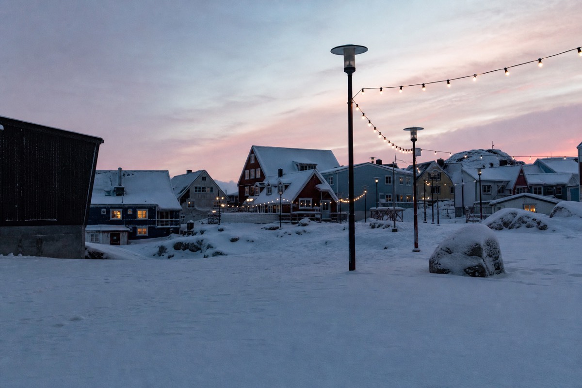 Snow-covered street in Rovaniemi, Finland at dusk with the Arctic Circle just outside town